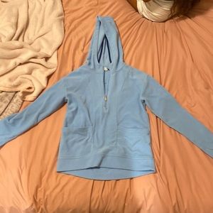 Blue hoodie with thumb holes and horizontal pockets.